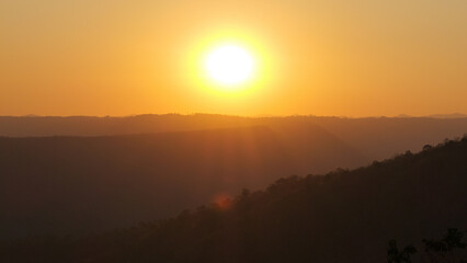 View of the setting sun behind the mountain.