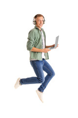 Young man with headphones and laptop jumping on white background. Online education