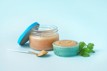 Bowl and jar with delicious caviar of capelin on blue background
