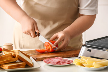 Woman preparing ingredients for delicious grilled sandwiches in kitchen