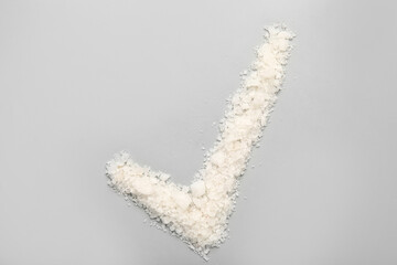 Check mark made of sea salt on grey background