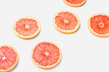 Composition with slices of ripe grapefruit on white background