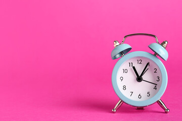 Alarm clock on pink background