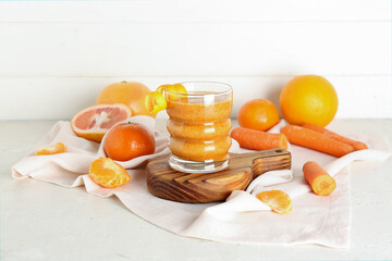 Glass of healthy smoothie and ingredients on light background