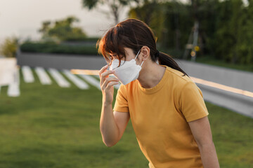 young Asian woman wearing N95 respiratory mask protect and filter pm2.5 or particulate matter...