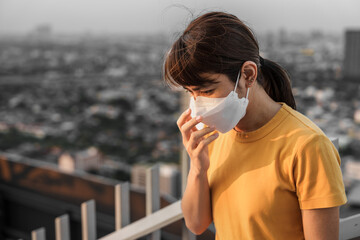 young Asian woman wearing N95 respiratory mask protect and filter pm2.5 or particulate matter...
