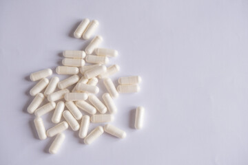 Fototapeta na wymiar Nutritional supplements or vitamins.White pills on a white background.White capsules with lactic acid bacteria on a white background. 