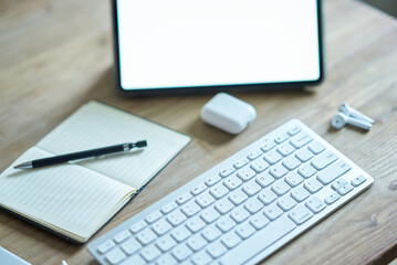 カジュアルなテーブルに置かれたタブレットPCなどビジネス道具一式