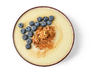 Bowl of tasty semolina porridge with blueberry and nuts on white background