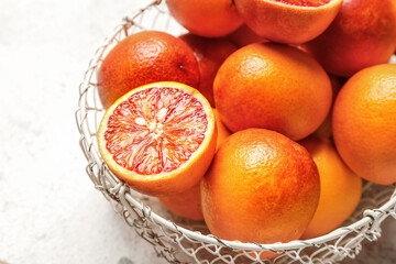 Basket with tasty blood orange fruits on white background