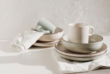 Modern ceramic tableware on table with copy space.  Trendy plates, cutlery and linen napkins scandinavian style.Space for text or menu . Business food brand template.