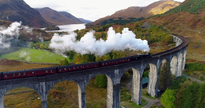Aerial pan shot of the Jacobite Express crossing the Glenfinnan Viaduct