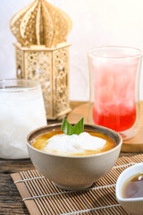 Bubur Sumsum served on wooden table, Javanese dessert porridge of rice flour, coconut milk with brown sugar syrup. A popular iftar food for breaking the fast Ramadan