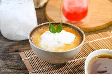 Bubur Sumsum served on wooden table, Javanese dessert porridge of rice flour, coconut milk with brown sugar syrup. A popular iftar food for breaking the fast Ramadan