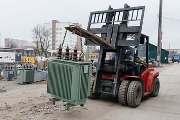 Forklift is putting cargo from warehouse to truck outdoors