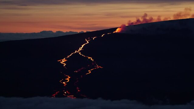 Impressive epic view of red hot molten lava river flowing from fissure on Hawaii Mauna Loa volcano eruption. Cinematic shot on RED camera at pink sunset. Scenic view glowing red hot lava river flow 4K