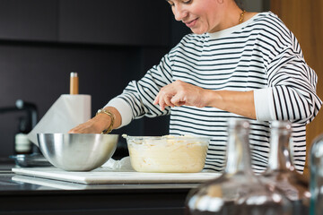 Woman hands putting apples while cooking apple pie