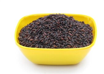 Black rice in a bowl on white background 