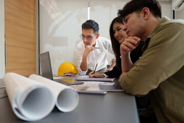 Architect and Engineer working with blueprints for architectural plan, engineer sketching a construction project, green energy concept
