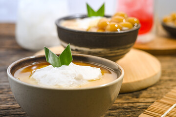 Bubur Sumsum served on wooden table, Javanese dessert porridge of rice flour, coconut milk with brown sugar syrup. A popular iftar food for breaking the fast Ramadan