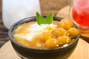 Bubur Sumsum Biji Salak or Candil Ubi served on wooden table, Indonesian traditional dessert...
