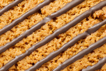 Chocolate stripes on oatmeal cookies close-up, background wallpaper, uniform texture