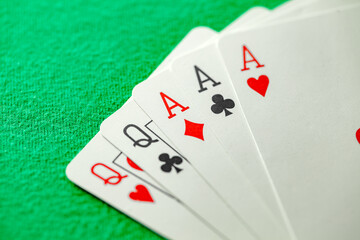 Playing cards, poker combination full house, three aces and two queens cross hearts diamonds suits