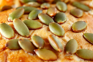 Sunflower seeds close-up on surface of baked bread crust, selective focus