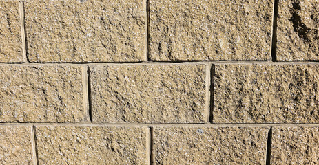 The wall is made of decorative rectangular light brown stone. Stone background