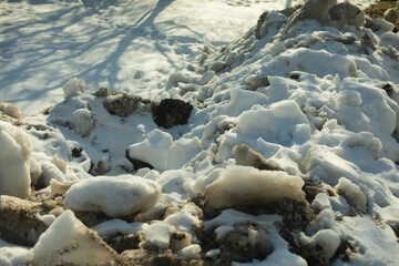 Snow removed from road. Pile of snow outside. Dirty roadside.