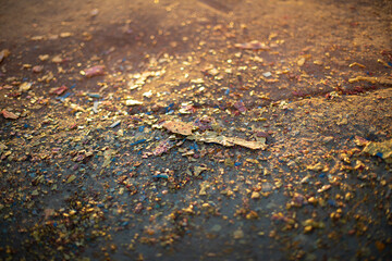 Paint on asphalt. Dirty texture in warm light. Lot of small particles on surface.