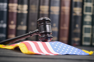 Judge Gavel and United States of America flag on a black wooden background.