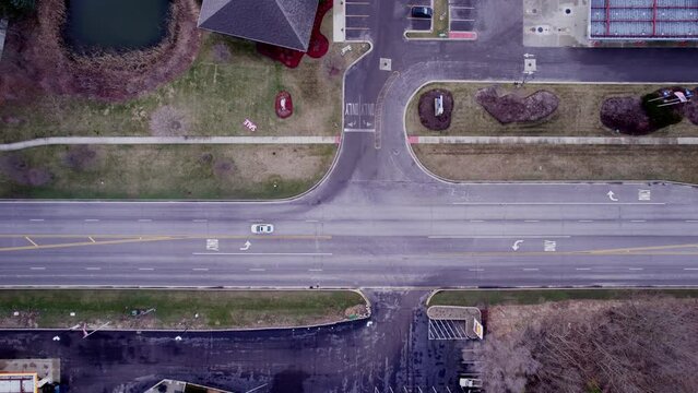 top down aerial of a small truck stop parking lot with semi trucks, dry vans and reefers parked next to highway. 4k USA
