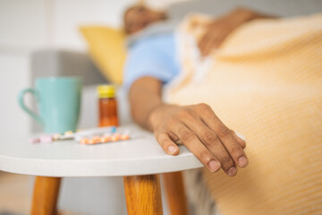 Obraz na płótnie Canvas Hand of a sleeping man on the side table with pills.