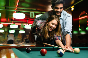 Couple dating, flirting and playing billiard in a pub