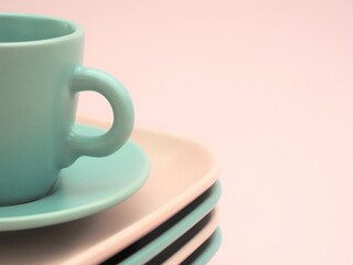 Close up de vajilla con platos y una taza de colores rosa y verde sobre fondo rosa
