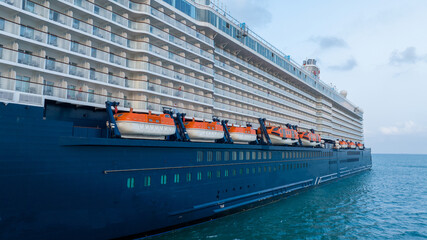 Safety equipment lifeboat. Orange lifeboat hanging over Sea on the side of a Cruise ship