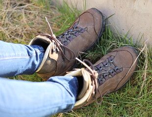 Hiker takes a break and rest her feet but do not take off her hiking boots