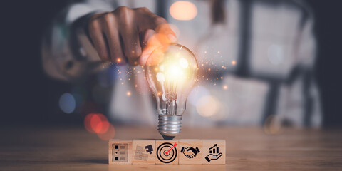 Human hand pointing at a light bulb,Finding new solutions to solve business problems,innovation and brain power from brainstorming,Finding Creativity and Inspiration,successful business ideas