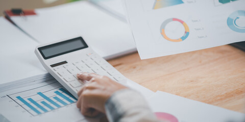 Businessman calculating figures in company financial documents with a calculator,analysis of company financial data,Planning to assess and review budgets,concept of finance and investment.