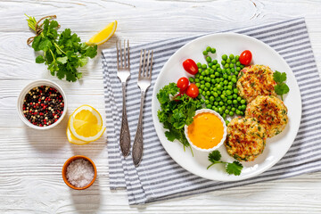 crab cakes with sauce, green peas, tomatoes