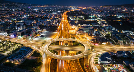 Aerial view of a illuminated multilevel junction ring road as seen in Attiki Odos toll road motorway interchange with Kifisias Avenue in Athens, Greece, during night time