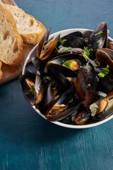 Boiled mussels in mussel pot with parsley