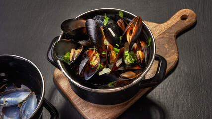 Boiled mussels in mussel pot with parsley