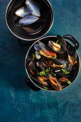 Boiled mussels in mussel pot with parsley. top view