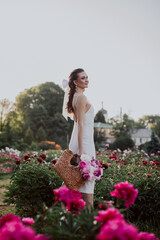 young woman with basket with pink peonies 