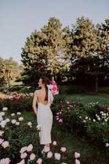 young woman with  pink peonies 