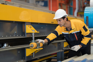 Manufacturing industrial in plant. Male engineer worker checking, repair and maintenance conveyor belt machine at manufacturing production lines in industry factory while use digital tablet