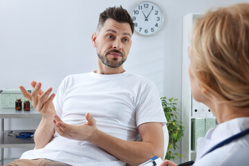 Doctor listening to patient's complaints during consultation in clinic