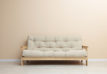 Comfortable sofa near beige wall on floor indoors
